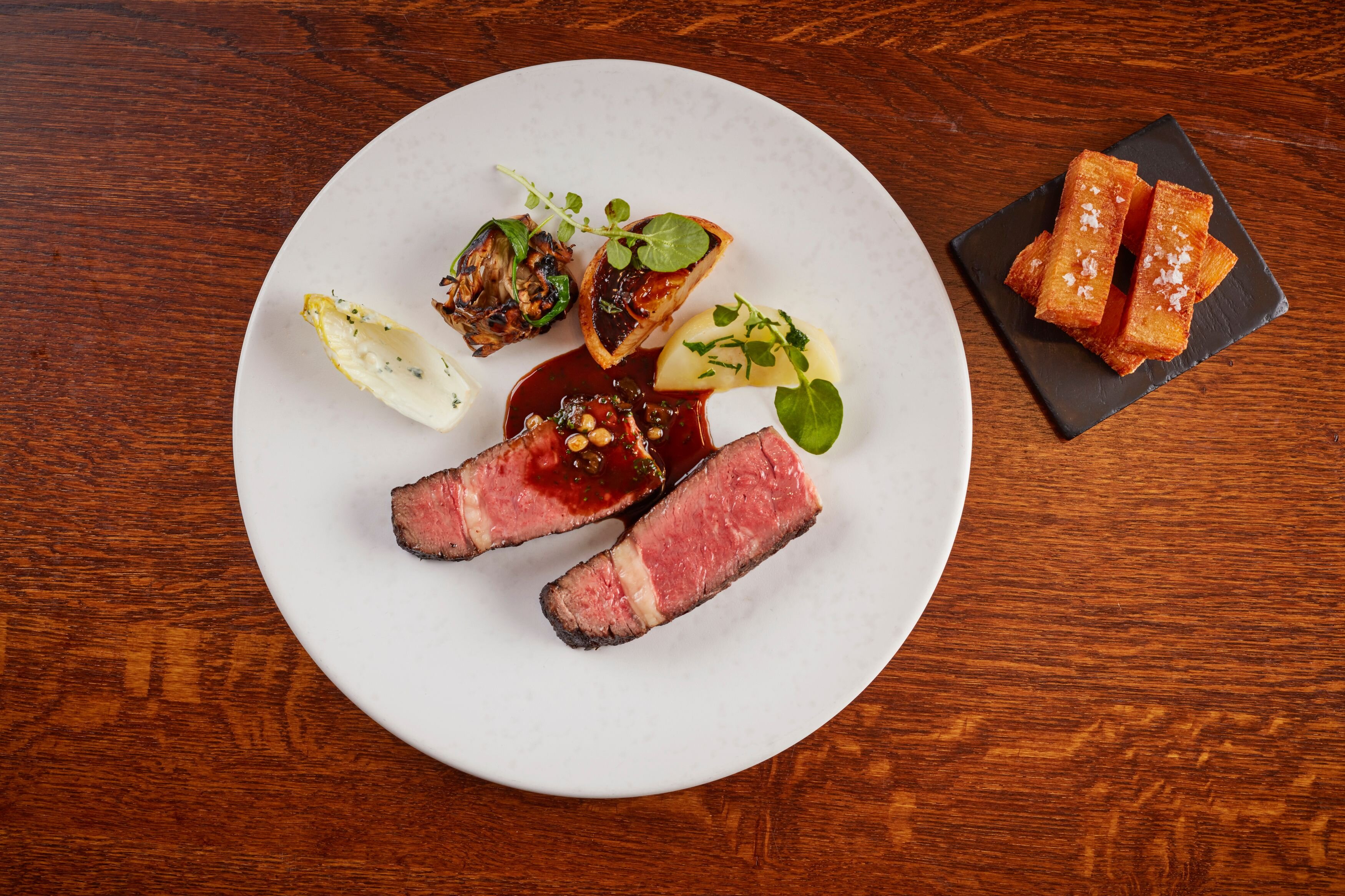 Adam Bennetts charcoal-grilled rib-eye, onion tartlet, salt-baked celeriac, grilled hen of the woods, a chicory and Cashel crozier blue cheese salad, Pommes Anna chips and a stout and pickled walnut Bordelaise sauce